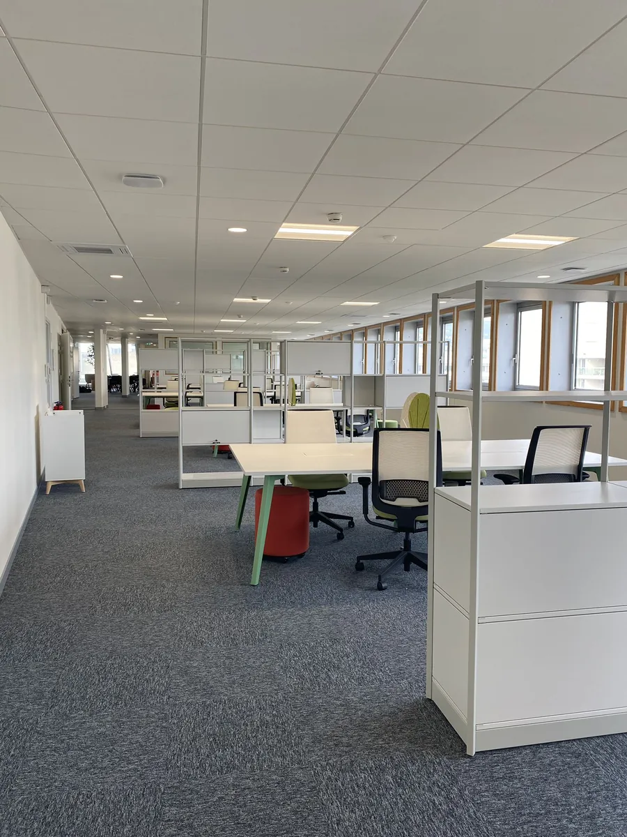Plateau de bureaux en open space avec moquette grise